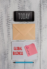 Word writing text Global Business. Business photo showcasing Trade and business system a company doing across the world Envelop smartphone notepad note clip marker old wooden vintage background