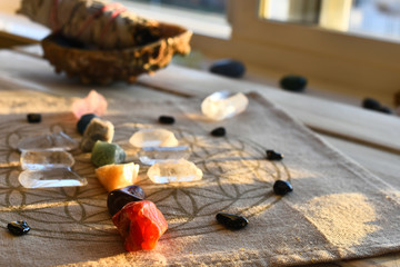 An close up image of chakra balancing crystals on a wooden table with glowing evening sunlight...