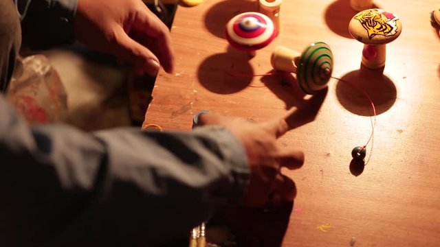 Street Vendor Showing how to Play with Handmade Spinners