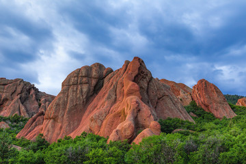 Red mountains rising from the green trees during sunset