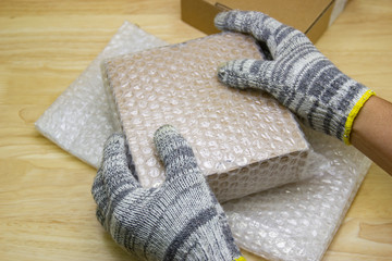 Fototapeta na wymiar hand of man hold bubble wrap, for protection parcel product cracked or insurance During transit