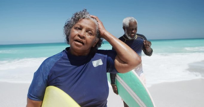 Senior couple with surfboards at the beach