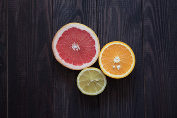 Fototapeta na wymiar lemon, orange and grapefruit on a wooden background
