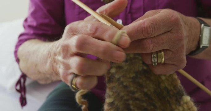 Senior woman knitting in his room of retirement home