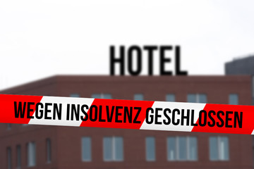 Ein Hotel und Absperrband mit dem Hinweis auf Schließung wegen Insolvenz