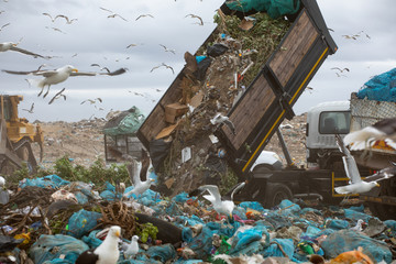 Rubbish piled on a landfill full of trash with vehicles working