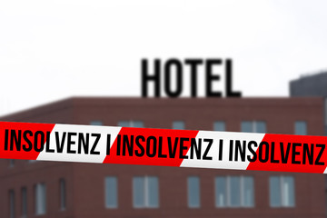 Ein Hotel und Absperrband mit dem Hinweis Insolvenz