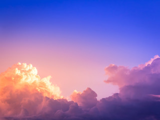 orange light in purple clouds in deep blue sky