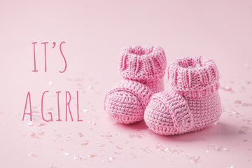 It's a girl text. Pair of small baby socks on pink background with copy space for your warm message, baby shower, first newborn party background, copy space, cute minimal postcard - 345466527