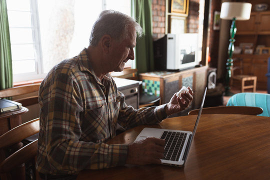 Senior man using laptop at home