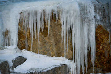 Scenic, beautiful view of ice shards hanging over the side of a rock wall in Yukon Territory, Canada. 