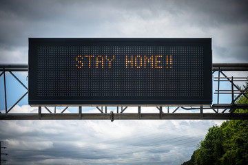 A digital highway sign pleads with drivers to "Stay Home" during the COVID-19 pandemic.