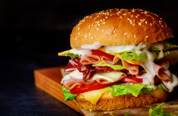 Sandwich with ham, lettuce, cheese and tomato.