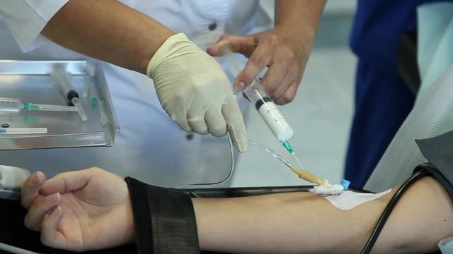 Nurse injects the white drug into a patient's vein with a syringe.Intubated patient connected to an artificial lung ventilation unit.