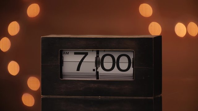 A retro flip clock flipping to 7:00 AM.