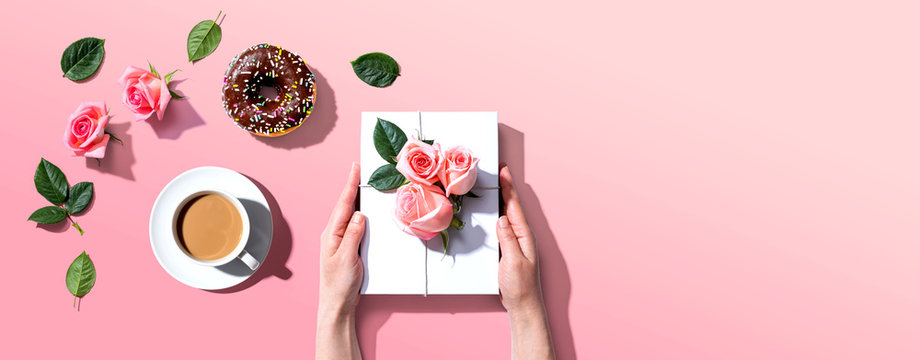 Female Hands Holding A Gift Box With Pink Roses Overhead View - Flat Lay