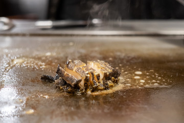 Grilled shellfish or seafood food on hot plate pan during Teppanyaki Japanese Chef cooking and grilling in restaurant. Delicious and Popular for tourists attractions in Kobe district, Hyogo, Japan