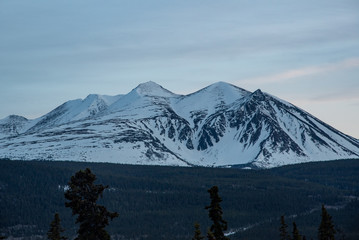 Fototapeta na wymiar Stunning mountains seen in northern Canada, Yukon Territory at sunset in the winter with snow capped peaks. 