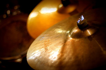 Closeup view of cymbals by a drum kit in a studio