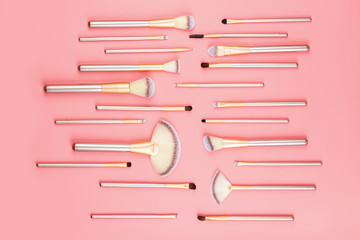 Cosmetic Makeup brushes on pink background. Flat lay, top view, copy space.