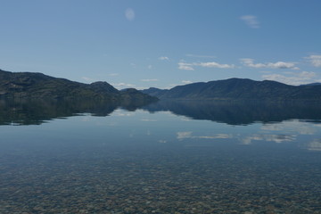 Calm lake in summer reflecting mountains