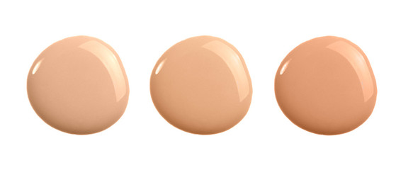 Set of shades of liquid concealer isolated on white. Beige nude liquid foundation smear smudge drop.