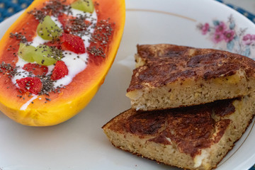 Breakfast with cinnamon banana cake, papaya topped with strawberries, grapes, plain yogurt and chia seeds