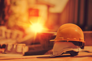 Hard hat or safety helmet on wood plate at construction site