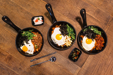 Flatlay of Bibimbap (Korean rice mixed with kimchi pork, tofu, seaweed and stir fried vegetables...
