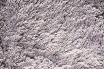 Artificial fur texture for background close-up. Fluffy grey material backdrop.