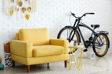 Interior of modern living room with comfortable armchair and bicycle