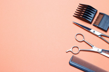 Hairdressing tools, scissors and comb on an orange background, replica of the space