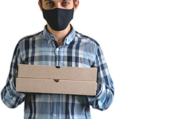 courier in a black mask and gloves with two cardboard boxes, close up of cardboard boxes against the background of a blurry man in a black mask