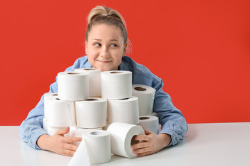 Woman with heap of toilet paper on color background. Concept of coronavirus epidemic