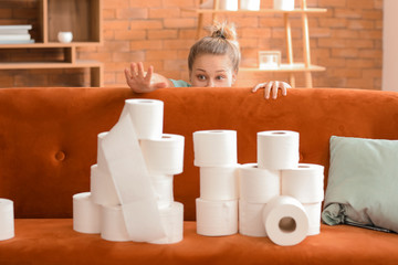 Woman with heap of toilet paper at home. Concept of coronavirus epidemic