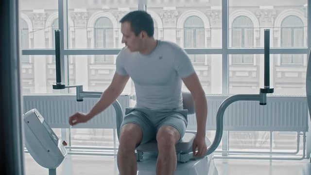 Young Guy Sitting Down On The Training Apparatus And Waiting For When It Will Be Possible To Start