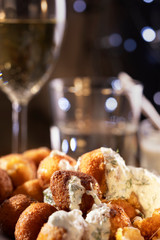 Round fried mozzarella cheese sticks under tzatziki sauce from yogurt with cucumbers and garlic.