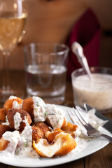 Fried mozzarella cheese balls under tzatziki sauce from yogurt with cucumbers and garlic, appetizer.