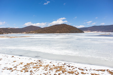 Potatso National Park or Pudacuo National Park during winter with mountain and frozen lake scenery with snow covered ground
