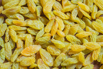 Green raisins spread on kitchen counter. Green raisin background.