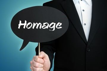 Homage. Lawyer in suit holds speech bubble at camera. The term Homage is in the sign. Symbol for law, justice, judgement