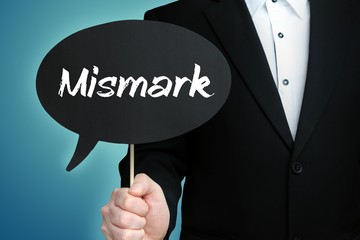 Mismark. Lawyer in suit holds speech bubble at camera. The term Mismark is in the sign. Symbol for law, justice, judgement