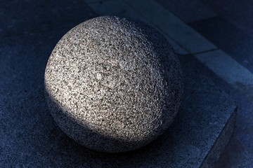 Granite ball close-up on the pavement in summer