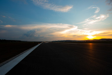 the runway of the airport at sunset