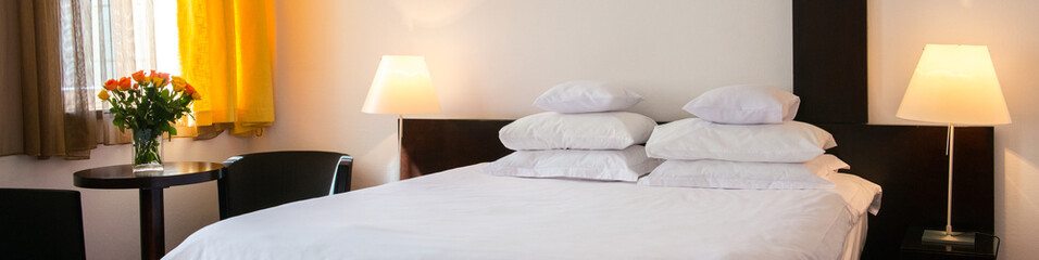 the bed with pillows and the blanket and bedside tables with lamps in the room where we rest