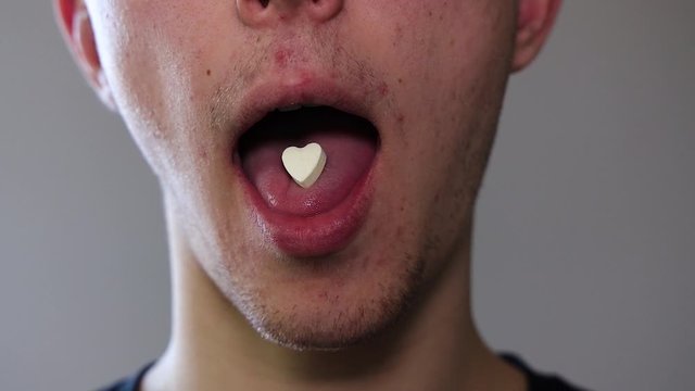 Man takes a heart shaped pill