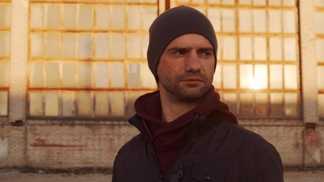 Portrait of a man over industrial buildings and sunset background.