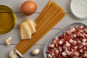 Cooking ingredients for italian carbonara on rustic surface.