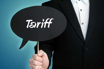 Tariff. Lawyer in suit holds speech bubble at camera. The term Tariff is in the sign. Symbol for law, justice, judgement