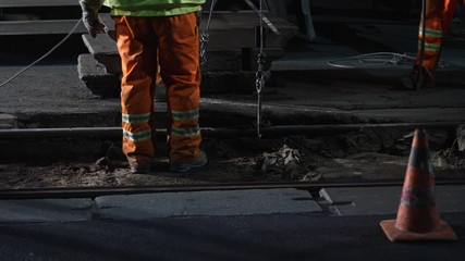 Construction workers removing concrete slabs during railway maintenance